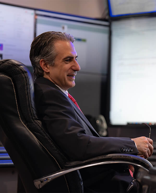 Sitting in front of a computer screen, Bob Coleman meets with an investor